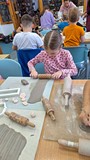 dzieci wykonują pracę plastyczną z gliny