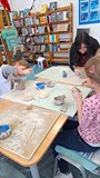 dzieci wykonują pracę plastyczną z gliny