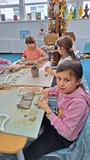 dzieci wykonują pracę plastyczną z gliny
