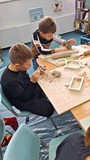 dzieci wykonują pracę plastyczną z gliny