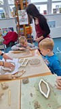 dzieci wykonują pracę plastyczną z gliny