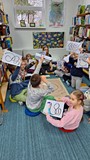 dzieci pozują do zdjęcia z pracami plastycznymi