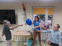 Dziewczynki próbujś przebić balona za pomoca skórki pomarańczy