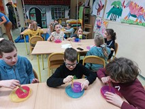 Chłopcy tworzą robaki za pomoca specjalnej masy plastycznej