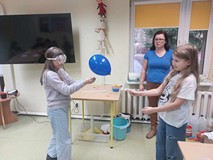 Dziewczynki próbujś przebić balona za pomoca skórki pomarańczy