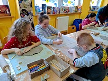 Na zdjęciu feriowicze wycinają w glinie wybrane wzory