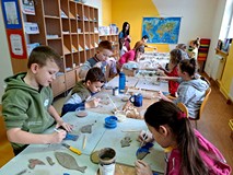 Na zdjęciu feriowicze malują wycięte z gliny morskie stworzenia