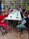 Dzieci czekają na reakcję chemiczną - zmianę koloru płynu w kubeczkach