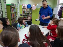 Prowadzący demonstruje wpływ wody i ciepłego powietrza z suszarki do włosów na bibułkowe kwiatki