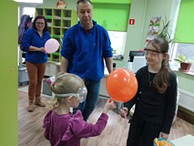 Michalina i Emilka ćwiczą dziurawienie balonów skórką z pomarańczy