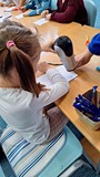 dziewczynka trzyma suszarkę w ręku i suszy kartkę
