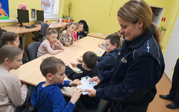 Policjantka wręcza dzieciom naorody za udział w konkursie.