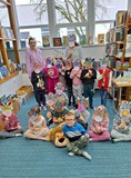 dzieci z bibliotekarką pozują do zdjęcia z maskami zebry