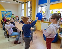 Na zdjęciu feriowicze skórką z pomarańczy powodują pęknięcie nadmuchanego balonu