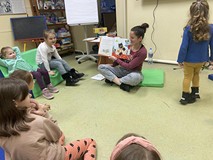 Bibliotekarka czyta dzieciom książkę i pokazuje obrazki