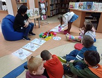 Na zdjęciu uczestnicy zajęć porządkują emocje Kolorowego potwora, wkładając kolorowe paski bibuły do