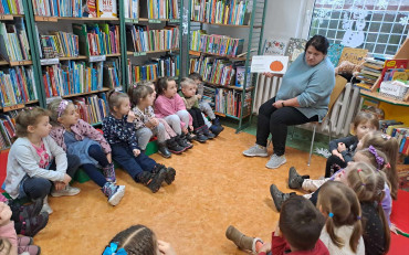 Bibliotekarka czyta dzieciom książkę.