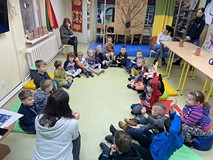 Dzieci podczas zajęć siedzą na kolorowych materacach