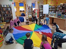 Na zdjęciu dzieci wysyłają Świnkę Malinkę w kosmos - podrzucając pluszową świnkę na chuście integrac