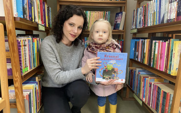 Dziewczynka i bibliotekarka prezentują książeczkę