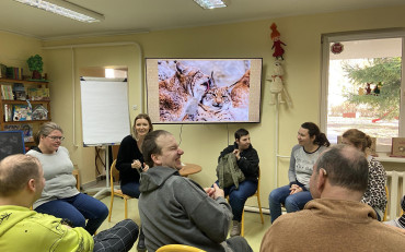 Bibliotekarka prezentuje uczestnikom informacje o kotach na monitorze