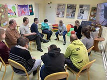 Grupa siedzi w kole podczas wspólnej zabawy