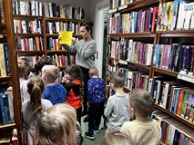 Bibliotekarka oprowadza dzieci po bibliotece