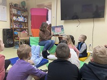 Bibliotekarka czyta dzieciom książkę i pokazuje obrazki