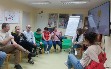 Bibliotekarka wraz z uczestnikami Warsztatów Terapii Zajęciowej podczas zajęć