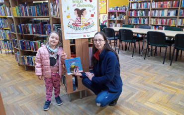 Dziewczynka wraz z bibliotekarką pokazuje książkę