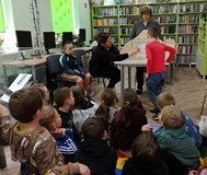 Dzieci z grupy „Wiewiórek” słuchają opowieści z teatrzyku kamishibai