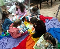 Dziewczynki z grupy „Wiewiórek” przeglądają dziecięce książki
