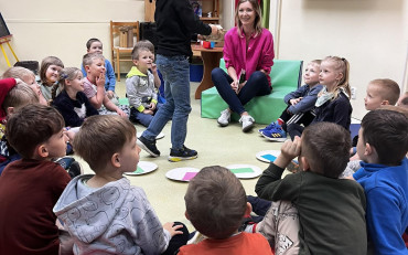 Dzieci siedzą w kole podczas zajęć
