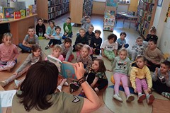 Na zdjęciu Wiola czyta dzieciom książeczkę o przygodach pary przyjaciól - Świnki Malinki i Słonia Le