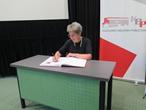 Wanda Budnik dokonuje uroczystego wpisu do Księgi pamiątkowej