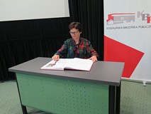 Ewa Chruściana dokonuje uroczystego wpisu do Księgi pamiątkowej