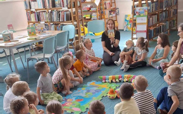 bibliotekarka czyta opowiadanie dzeciom