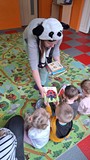 bibliotekarka daje dzieciom książki