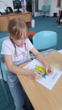 dziewczynka wykonuje pracę plastyczną