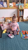 dziewczynka  bawi się w bibliotece