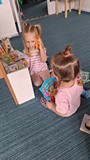 dwie dziewczynki bawią sie w bibliotece