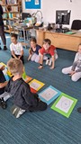 dzieci grają w dużą grę planszową na dywanie