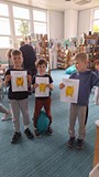 dzieci pozują  do zdjęcia ze swoją pracą plastyczną