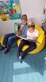 chłopcy oglądają ksiażki w naszej bibliotece