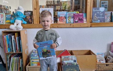chłopiec pozuje z pakietem Mała Książka, Wielki czlowiek