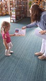 bibliotekarka wręcza dziewczynce dyplom uznania