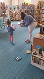 bibliotekarka wręcza dziewczynce dyplom uznania