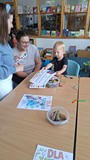 bibliotekarka wręcza chłopcu dyplom uznania
