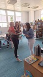 bibliotekarka wręcza chłopcu dyplom uznania