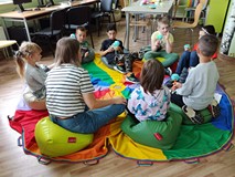 Dzieci rozmawiają z panią Beatą Piwar siedząc w kole